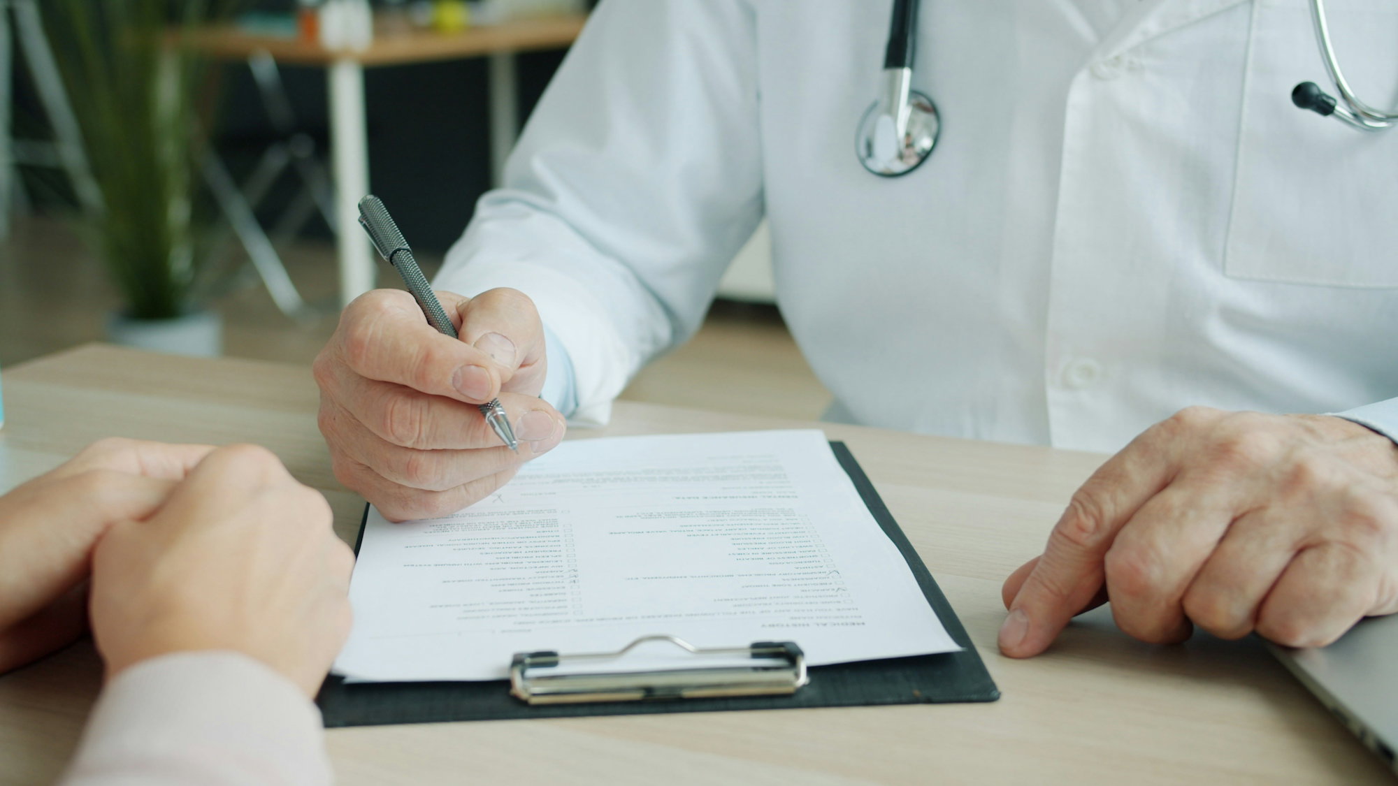 doctor-writing-on-a-patient-s-chart.jpg Doctor writing on a patient's chart